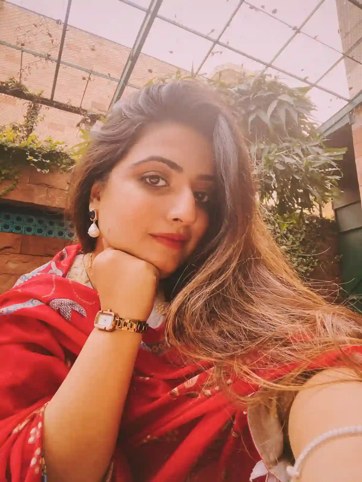 Woman wearing 18k Gold Plated watch and pearl drop earrings in outdoor garden setting