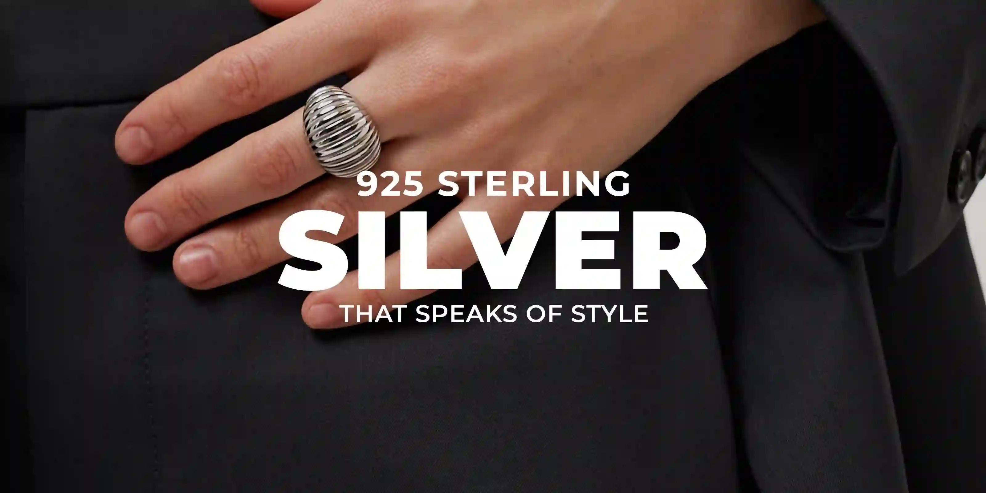 Hand wearing a bold 925 sterling silver ribbed ring on black fabric background