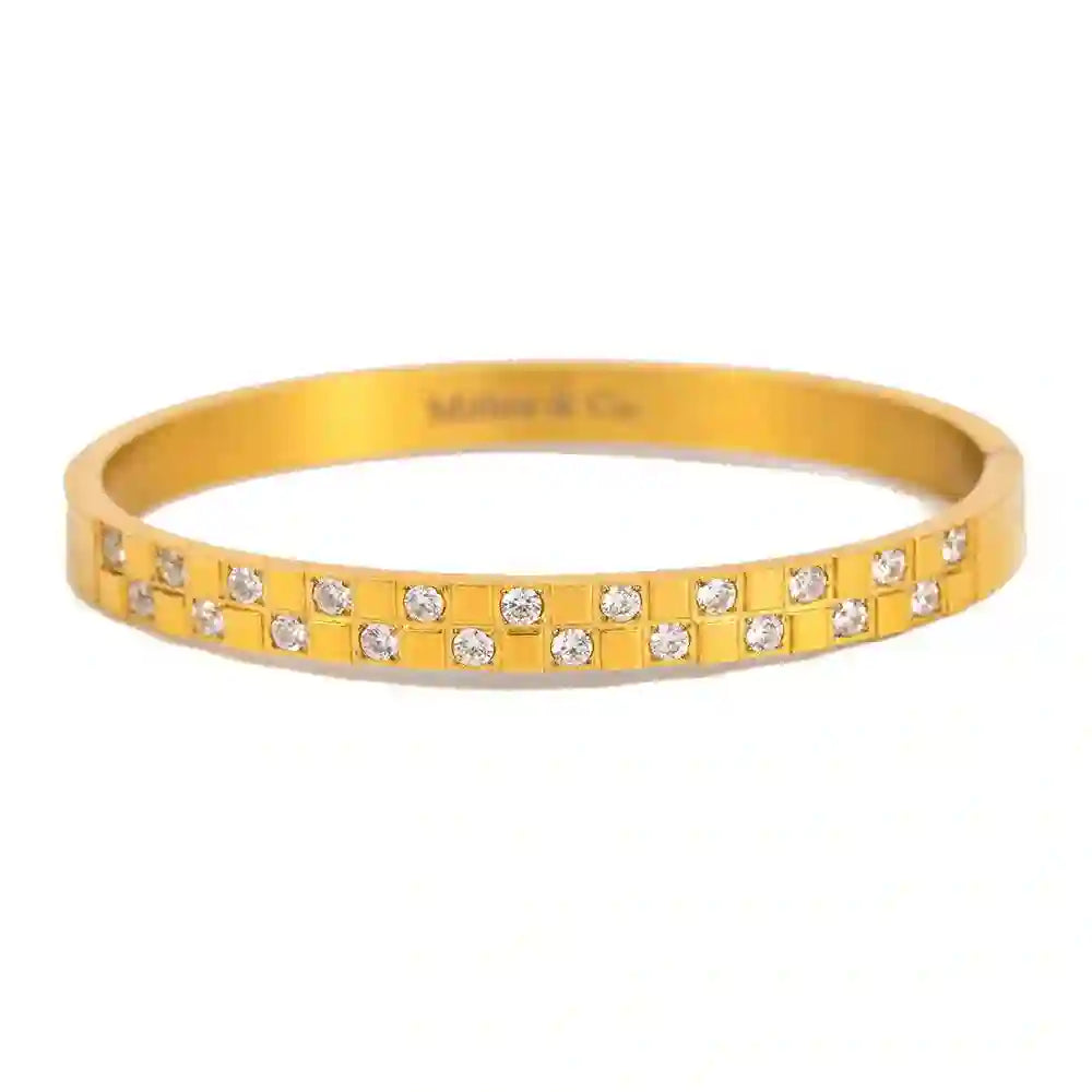 A gold-plated stainless steel cuff bracelet with a hinge closure, featuring a pattern of set diamonds.