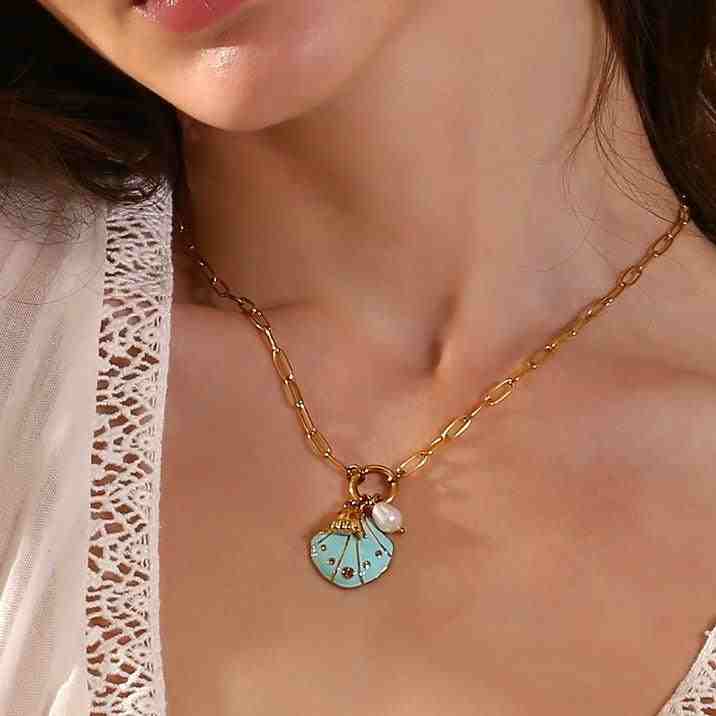 Wearing 18k gold plated Beach Seashell Necklace Charm - Coastal Essence. Buy Now.