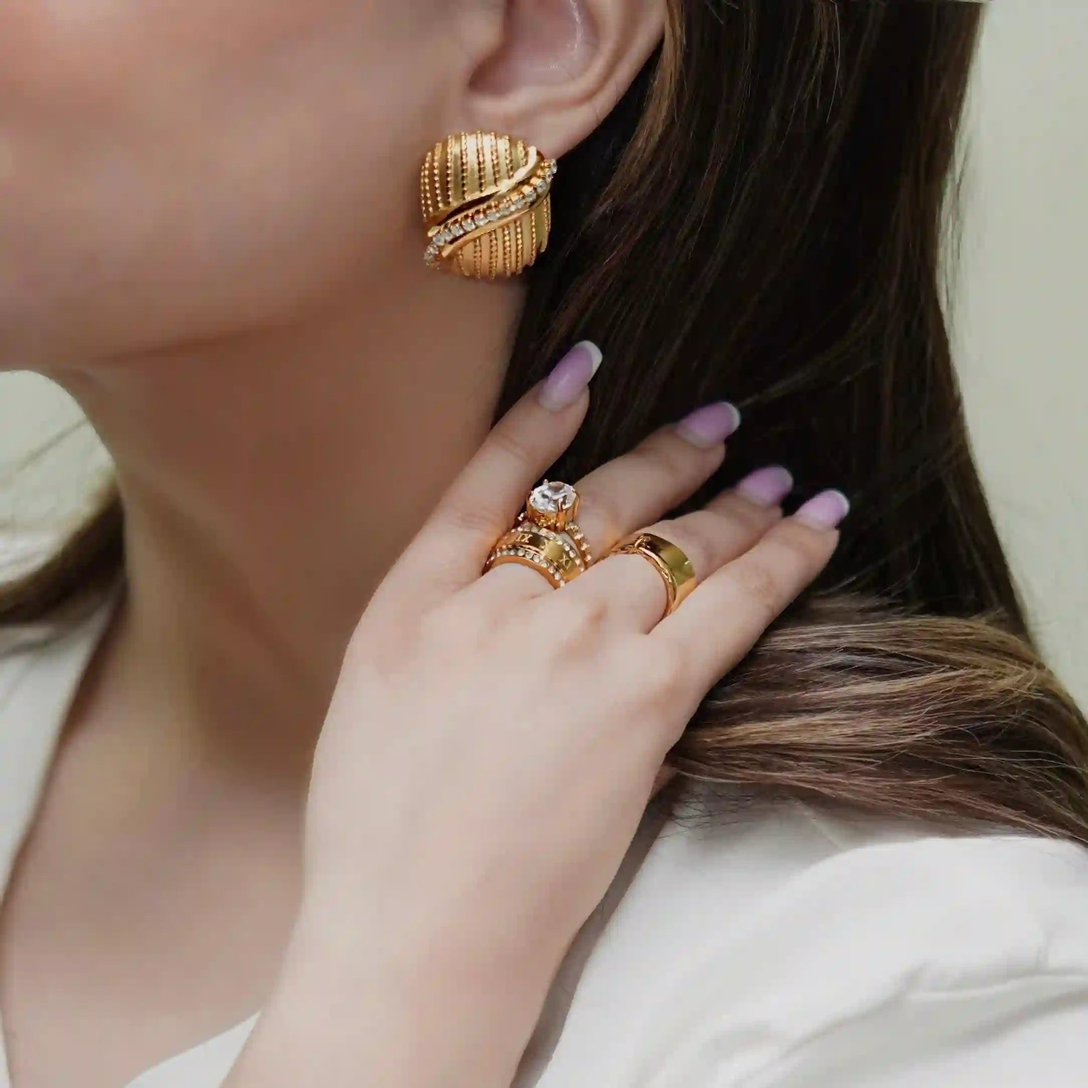 Girl wearing gold plated rings and studs. Buy now at Mithra and Co.