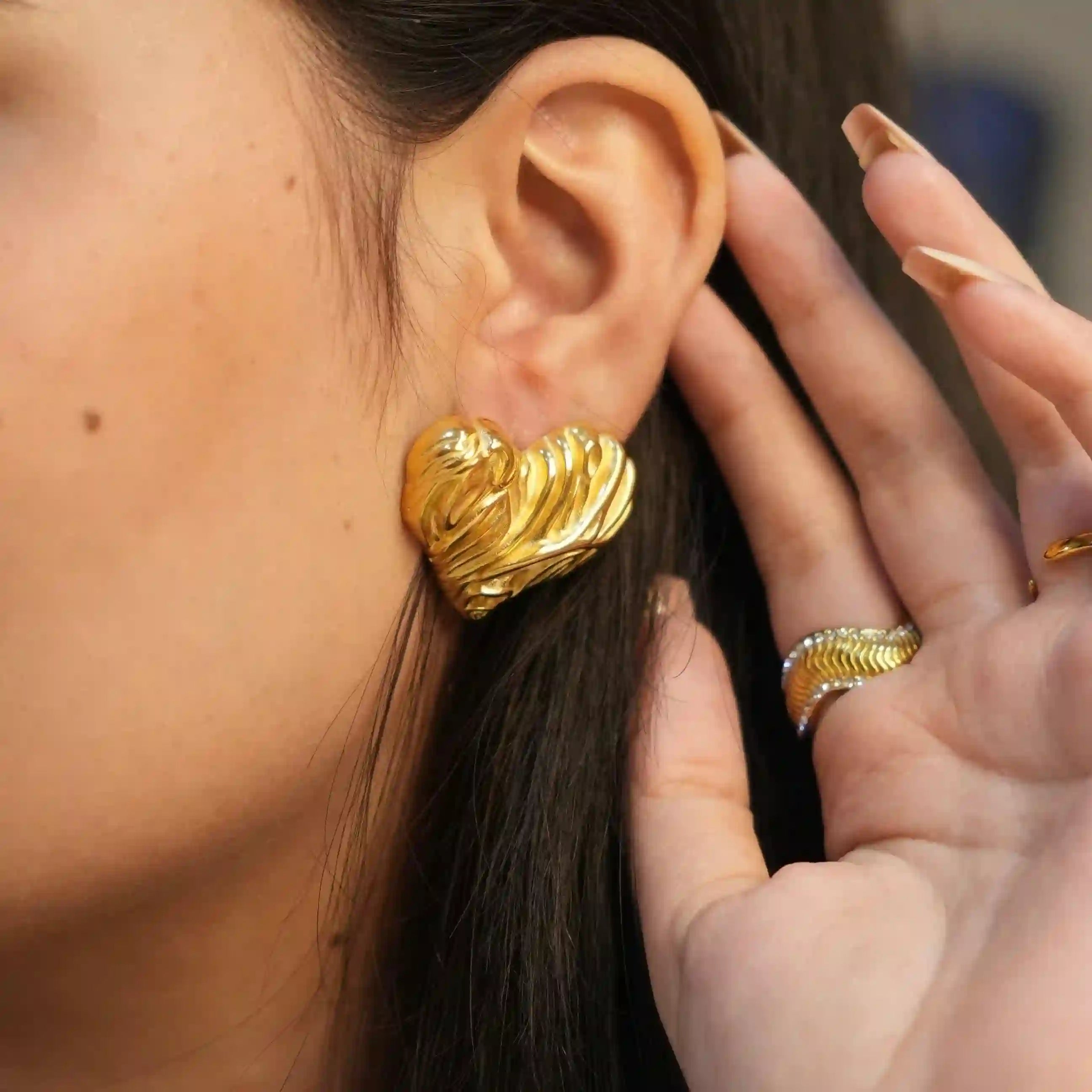 Girl wearing Gold Plated heart studs. Shop at Mithra and Co.