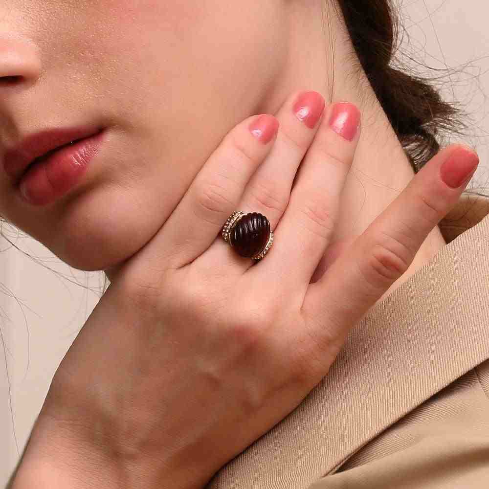 Girl wearing 18k gold plated Luminara Ring with a red amber stone. Shop at Mithra and Co.