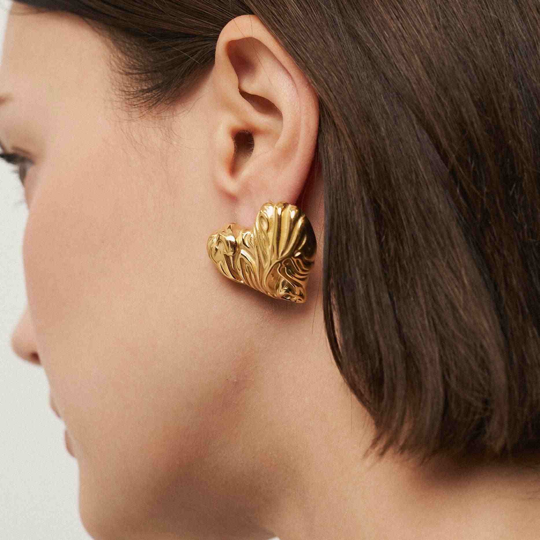 Girl wearing 18k Gold Plated heart shaped stud earrings: Mimosa. Buy at Mithra and Co.