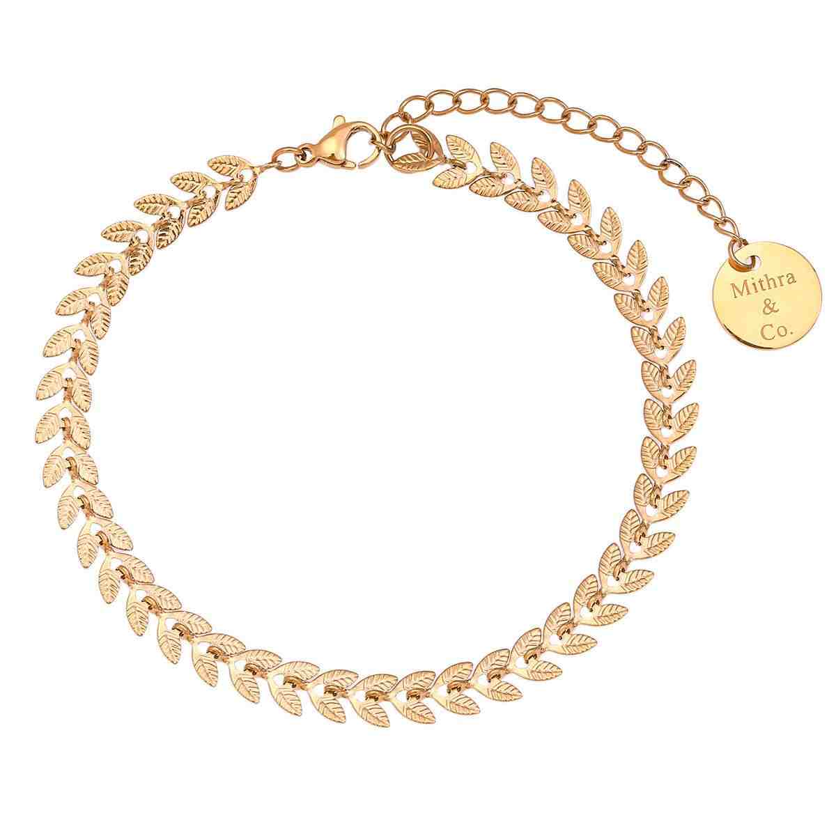 A gold-plated stainless steel anklet with leaf-shaped charms, featuring a chain design and a brand tag attached to the leaf on a gold-plated chain.