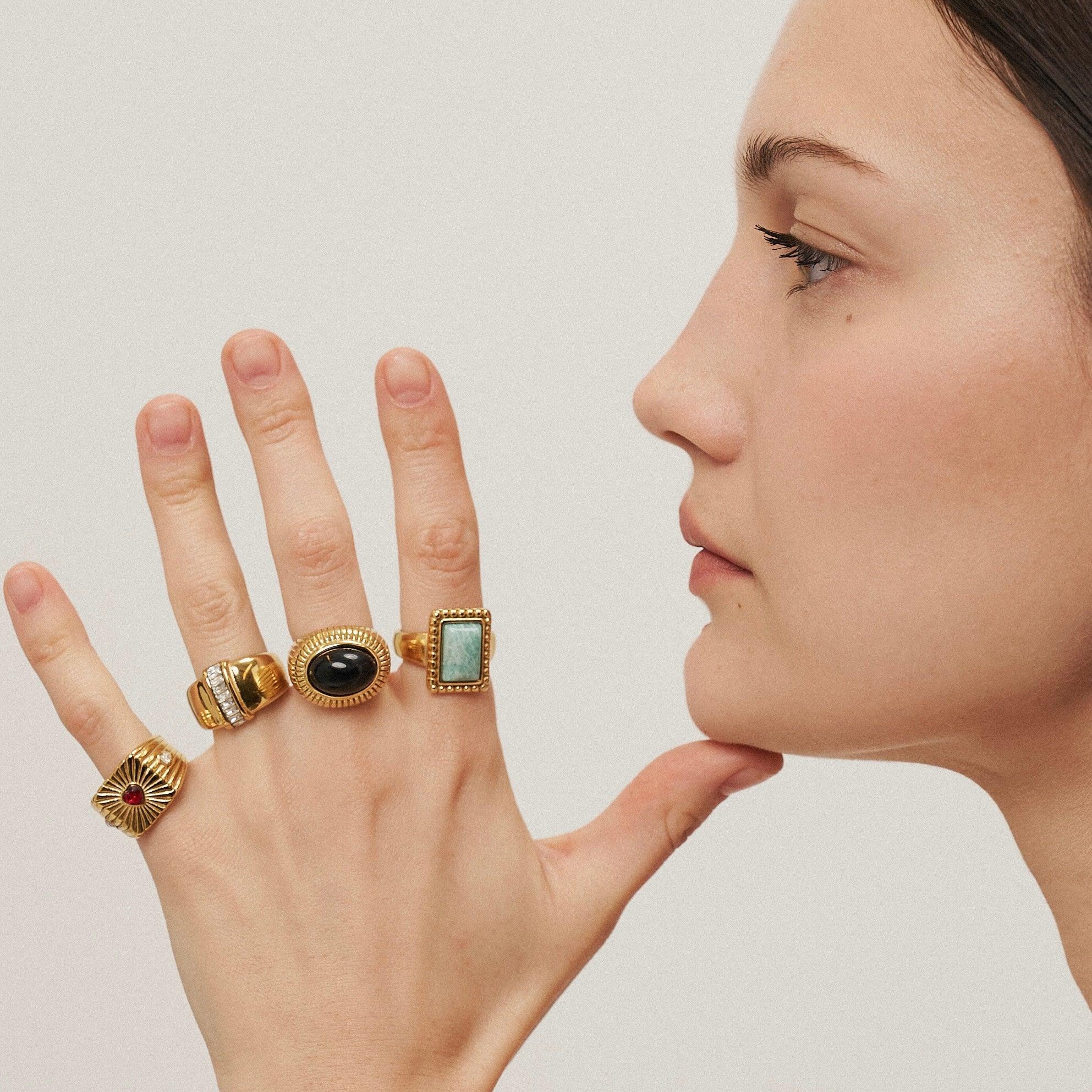 Girl wearing 18k gold plated rings in all fingers. Buy at Mithra and Co.