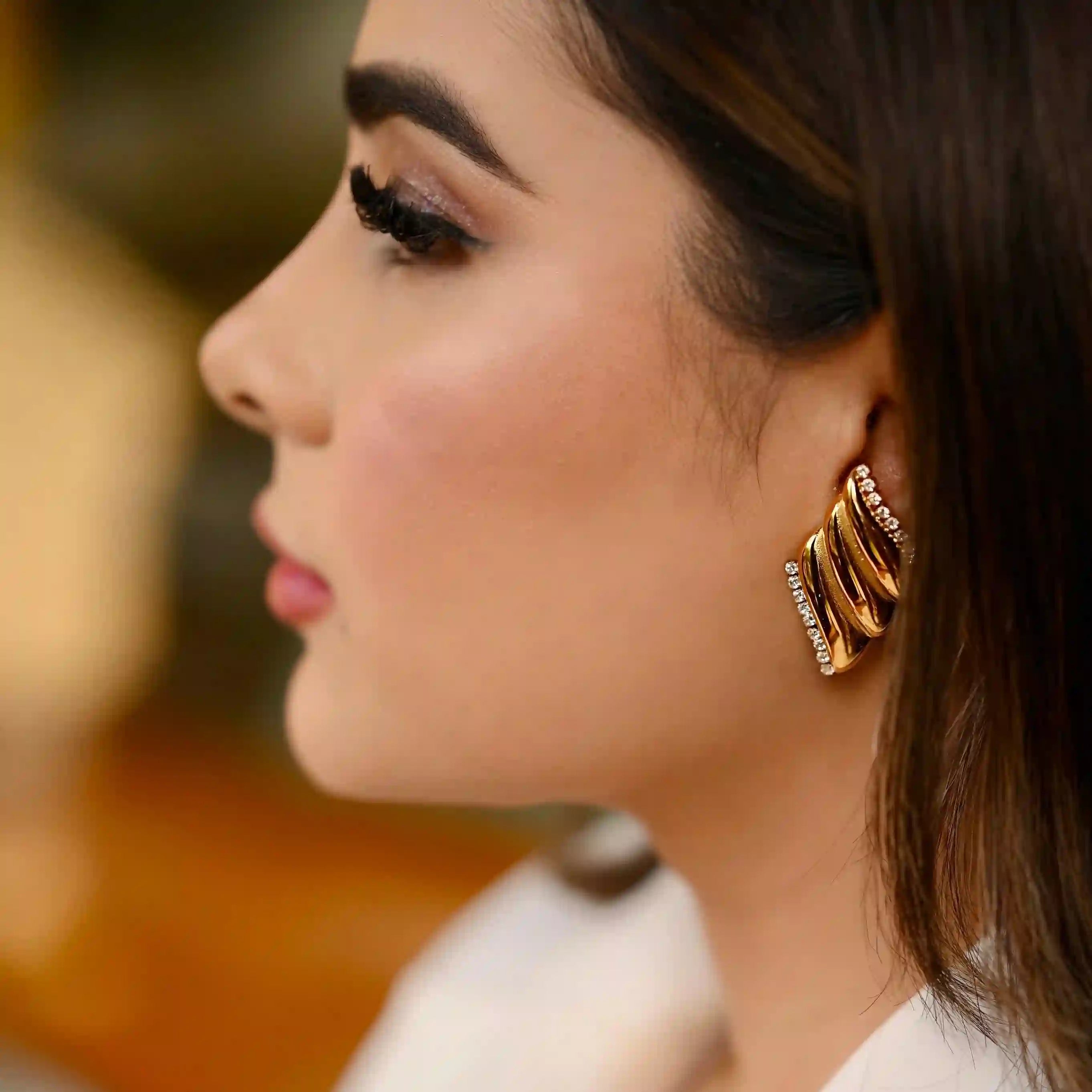 Girl Wearing 18k Gold Plated Fire Flame Earrings - Papyrus. Shop at Mithra and Co.