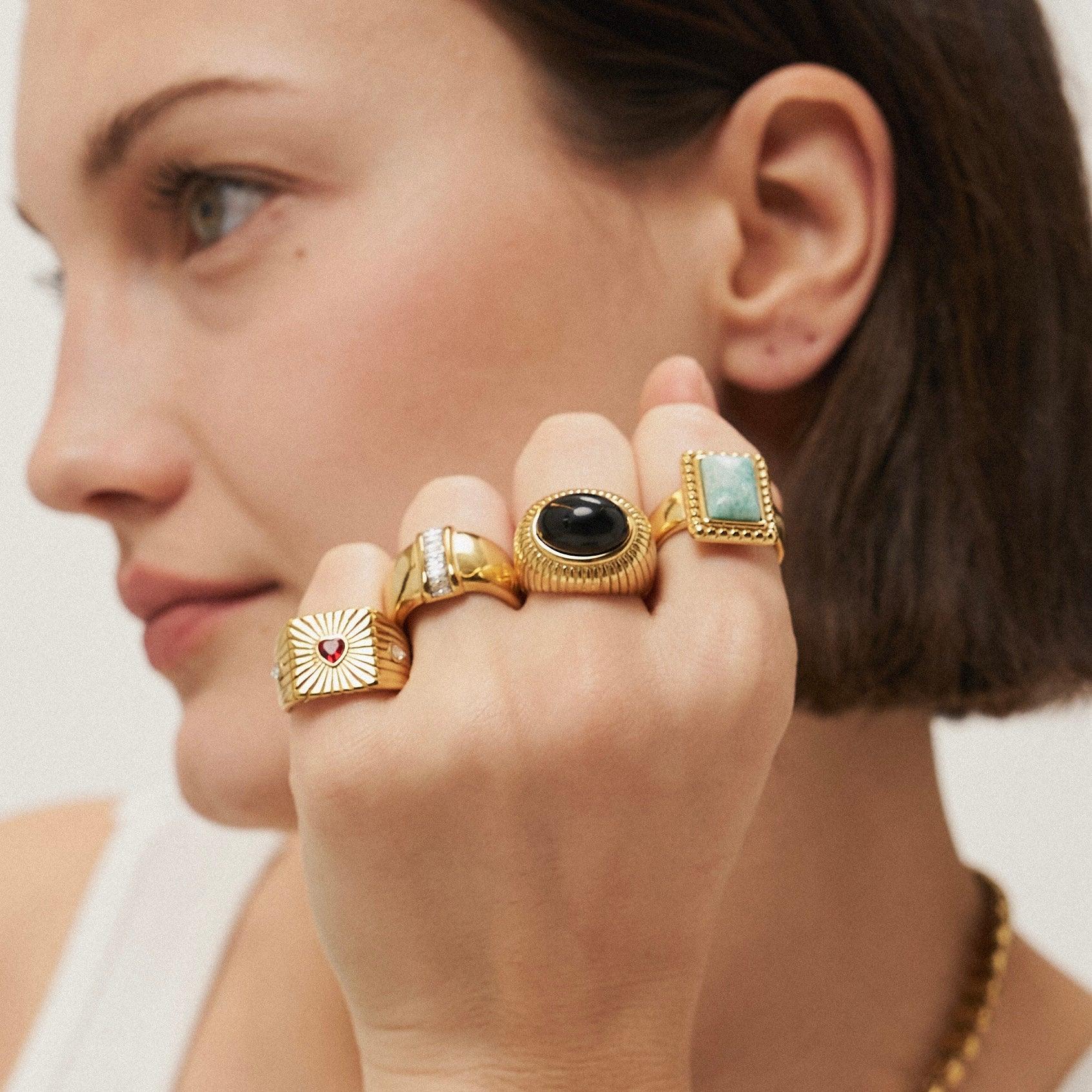 Girl wearing gold rings with stones. 18k gold plated. Mithra and Co.