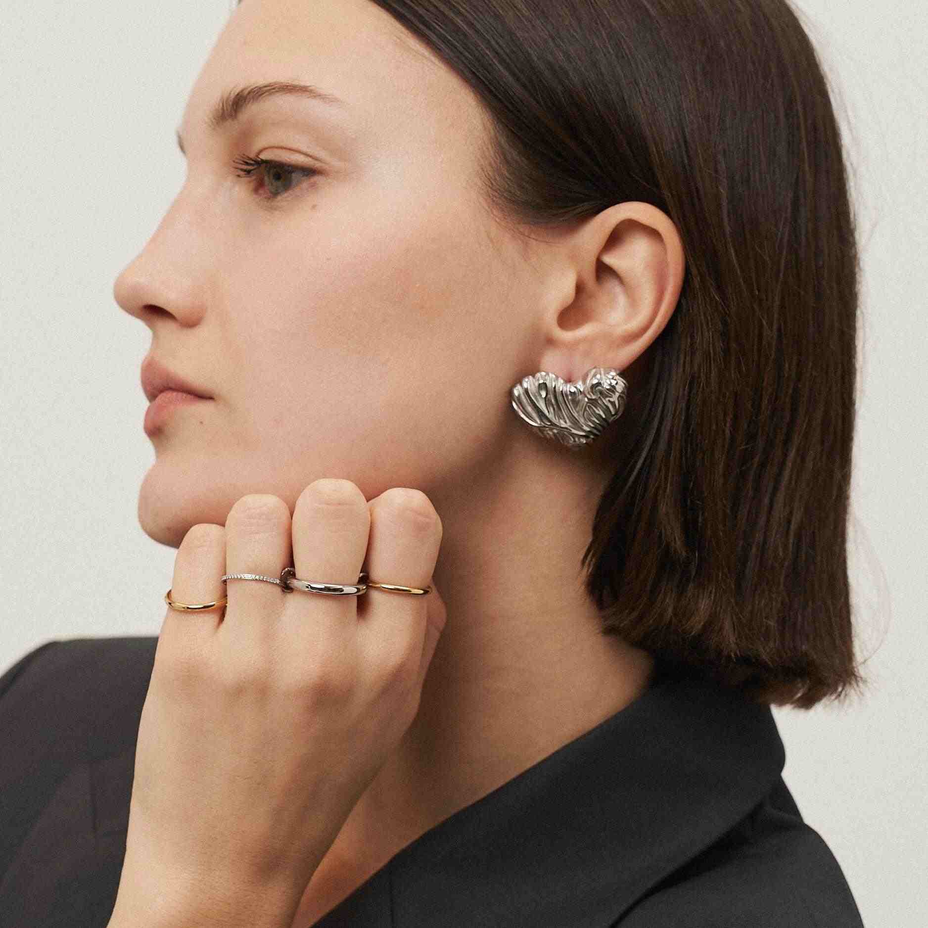 Girl Wearing Silver Plated heart earrings. Shop at Mithra and Co.