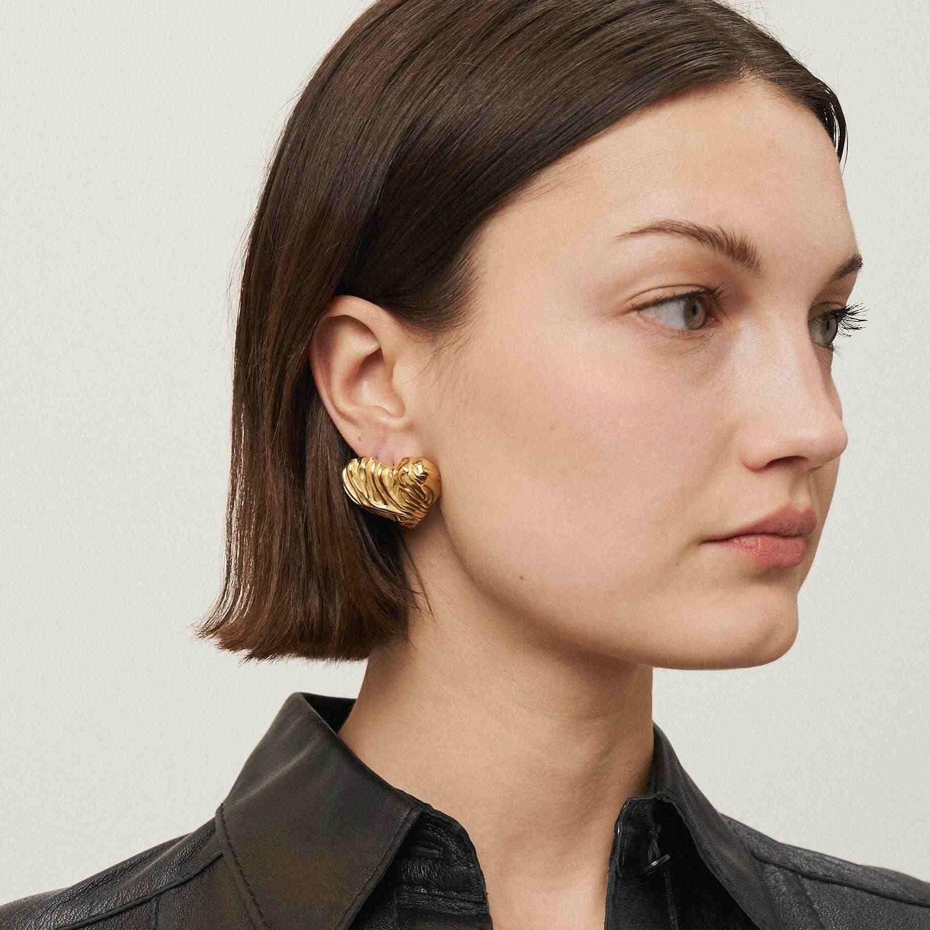 Girl wearing Mimosa: 18k Gold Plated heart shaped stud earrings. Shop at Mithra and Co.