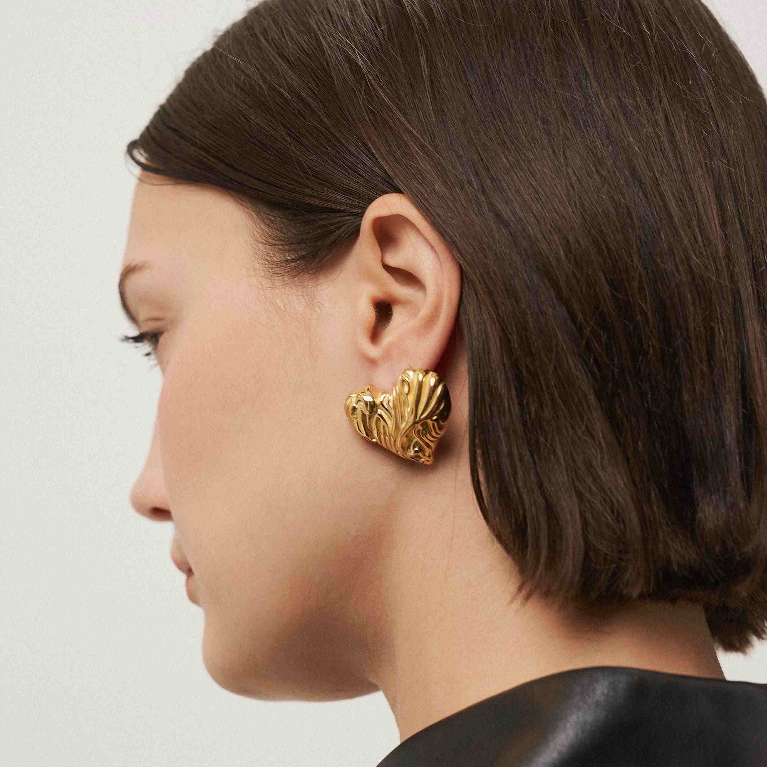 Girl wearing gold plated stud earrings. Shop at Mithra and Co.