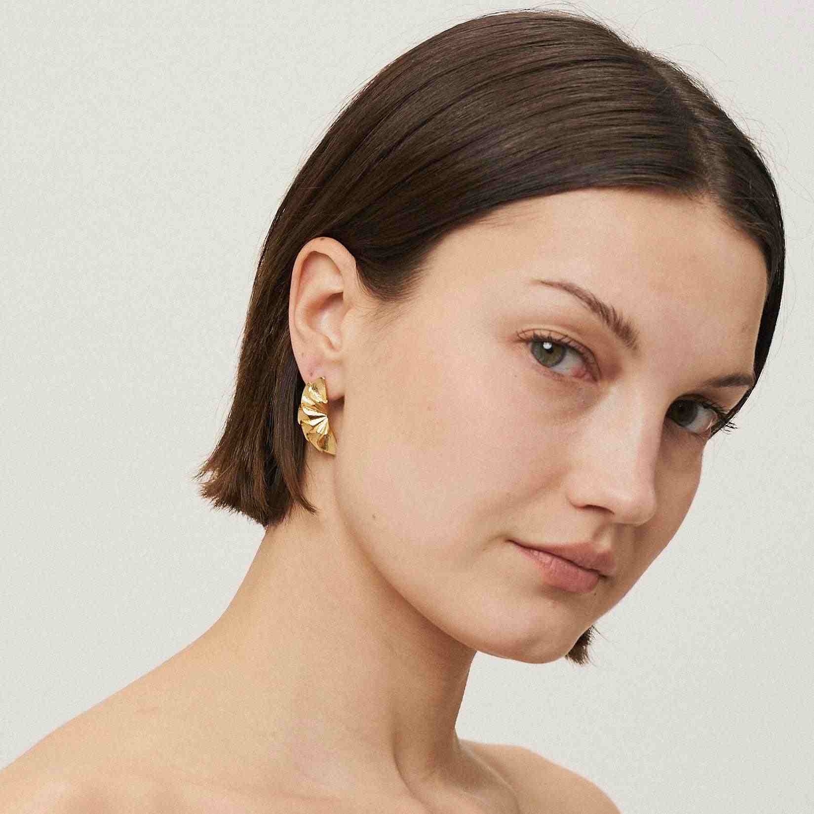 Girl wearing 18k Gold Plated Flower Earrings. Shop Flora Earrings at Mithra and Co.
