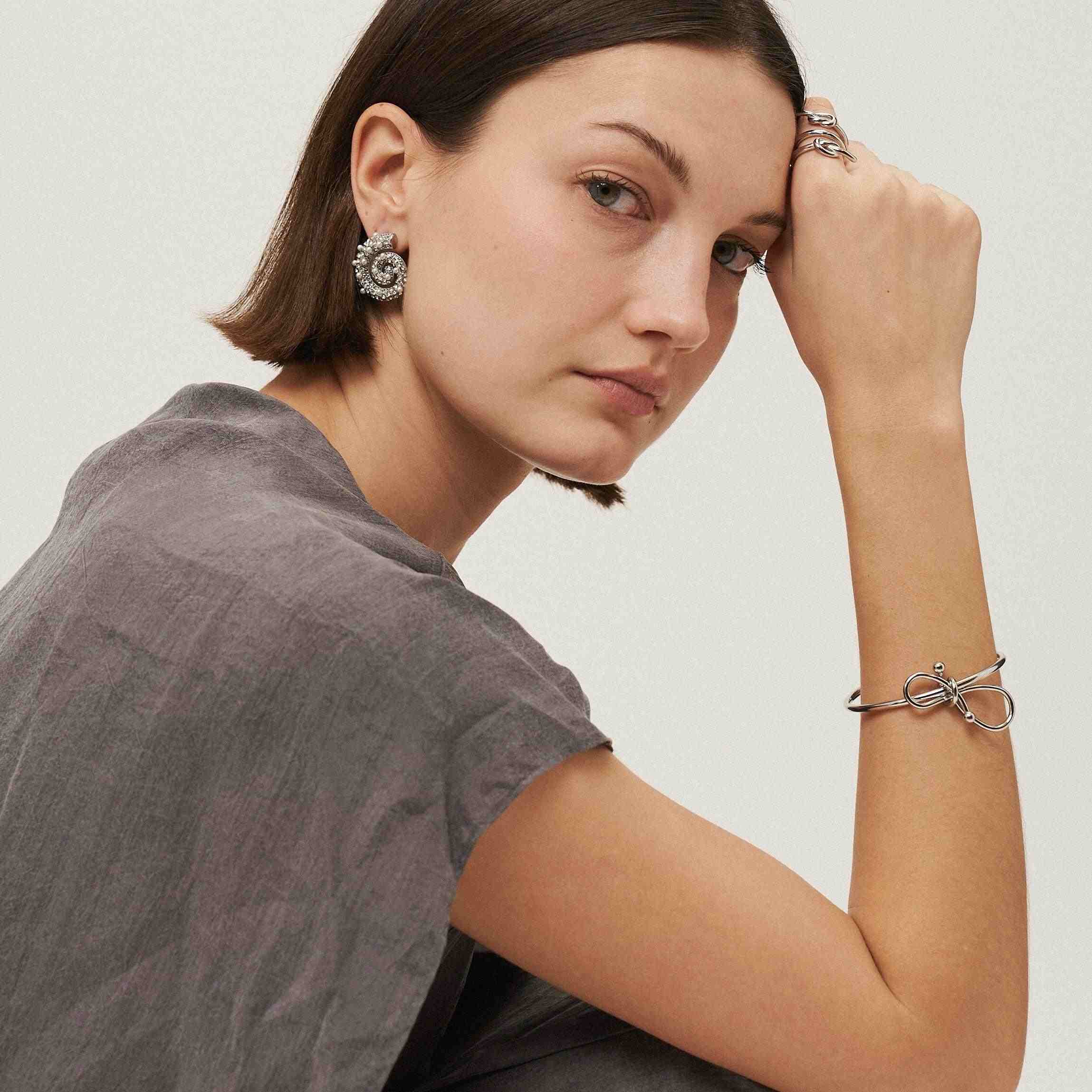 Girl wearing silver plated Elegant Love Knot Cuff Bracelet. Shop at Mithra and Co.
