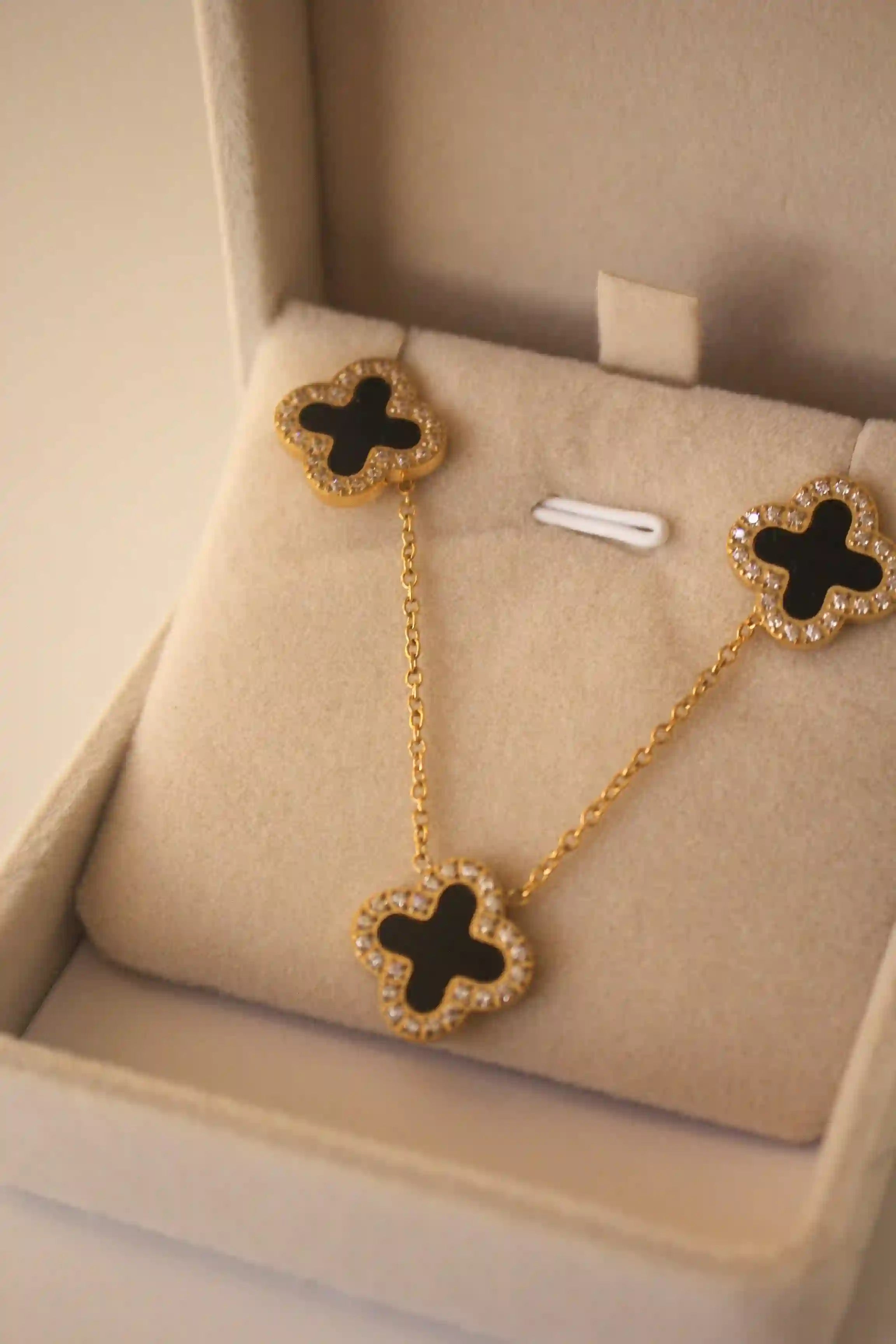 18k Gold plated Clover Necklace Set of 3. Zircons around and black stone in center. Shop Now.