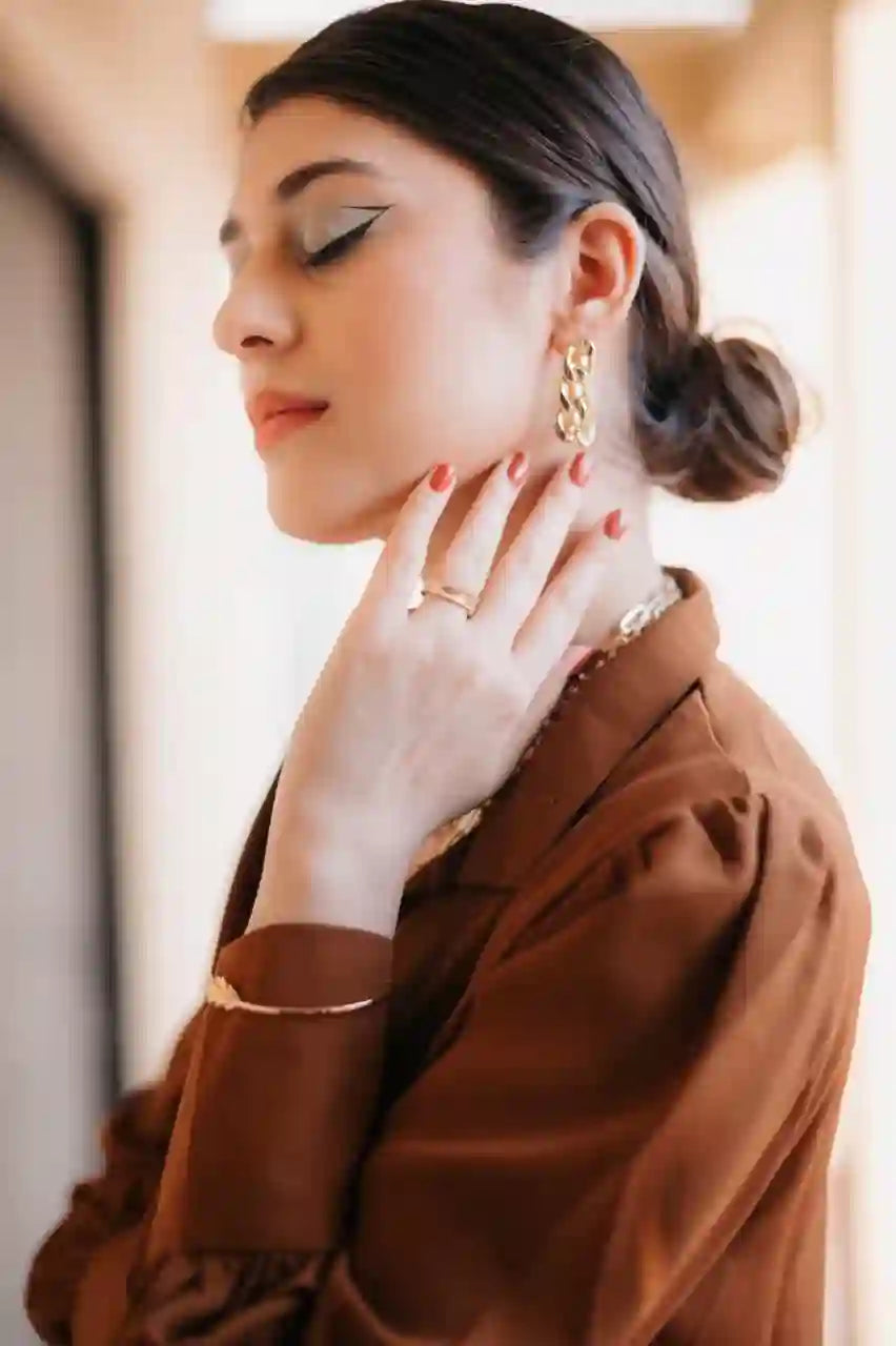 woman wearing 18k Gold Plated chain link earrings and bracelet with brown blazer in soft indoor light